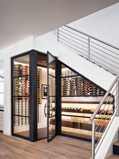 a wine store with stairs leading up to the second floor and glass doors that open