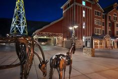 a horse statue in front of a red barn at night