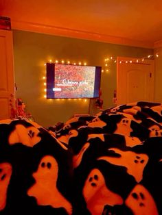 a room filled with lots of black and white stuffed animals in front of a flat screen tv