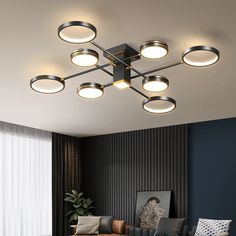 a living room filled with lots of furniture and lights on top of the ceiling next to a window