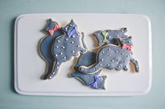 three decorated cookies sitting on top of a white plate