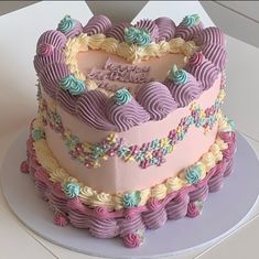 a heart shaped cake on top of a white plate with pink and blue frosting