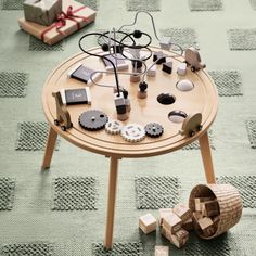 a wooden table topped with assorted items on top of a green carpeted floor