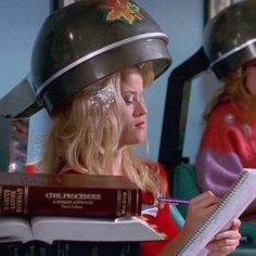 a woman in a helmet sitting at a table with books