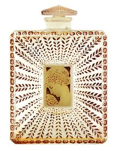 a decorative glass box with an animal on it's face and leaves in the center