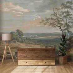 an empty room with a painting on the wall and a wooden chest next to it