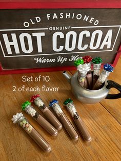 six miniature bottles with candy in them sitting next to a hot cocoa sign