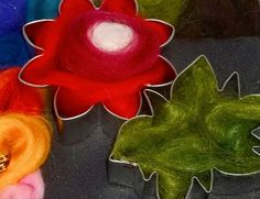 several different colored felt flowers sitting on top of each other