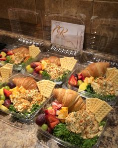 four plastic containers filled with food on top of a counter next to a marble counter