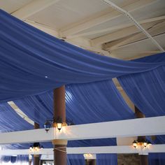 the ceiling is covered with blue draping and lights are hanging from it's sides