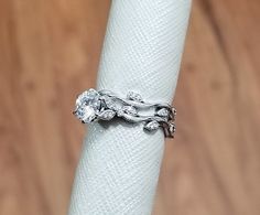 a close up of a ring on top of a white napkin with wood floor in the background