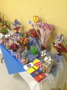 an assortment of candy and candies on a blue table cloth with yellow walls in the background