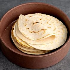 a bowl filled with tortillas on top of a table