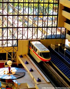 a train traveling through a train station filled with lots of windows next to a platform