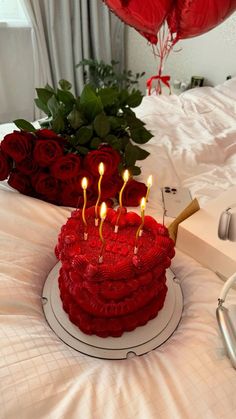 a red cake with candles sitting on top of it