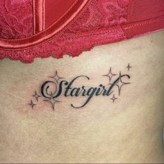 a woman's stomach with the word stargirl tattooed on her lower side ribcage