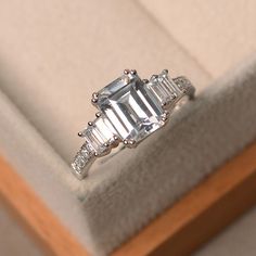 an engagement ring with three baguettes in it sitting on top of a box