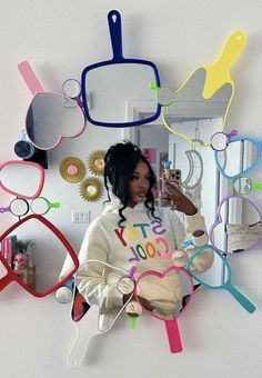 a woman taking a selfie in front of a mirror with colorful glasses on it