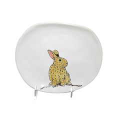 a white plate with a yellow rabbit on it's side and a black dot around the edge