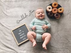 a baby laying on a blanket next to doughnuts