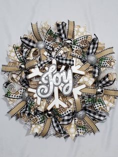 a wreath with the word joy written on it and bows in different colors, shapes and sizes