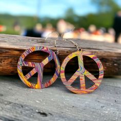 the peace sign earrings are made out of wood and have multicolored designs on them