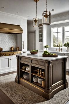 a large kitchen with an island in the middle and two lights hanging from the ceiling