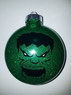 a green ornament with an image of the incredible hulk on it's face