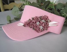 ALL ORDERS TOTALING OVER $35 SHIP FREE I designed this Pink golf visor making an adorable Wine checked ribbon flower. I added small rhinestone accents to the flower. This hat is so cute. Visor has velcro back. See more hats and visor here: https://www.etsy.com/shop/theraggedyrose?ref=seller-platform-mcnav&section_id=10557807 Custom orders alway welcome. Thanks for visiting my shop. Pink Visor For Spring, Spring Pink Visor (one Size Fits Most), Spring Pink Visor, One Size Fits Most, Pink Visor For Spring, One Size Fits Most, Adjustable Pink Beach Visor, Pink Visor With Uv Protection, Adjustable Pink Visor, Adjustable Summer Visor With Upf 50+, Pink Adjustable Visor