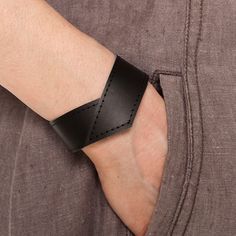 a person wearing a black leather wristband