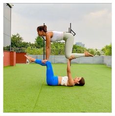 two women are doing yoga on the grass