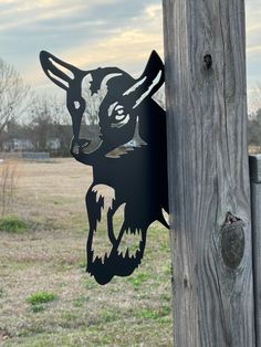 a wooden post with a paper cut out of a dog's head on it