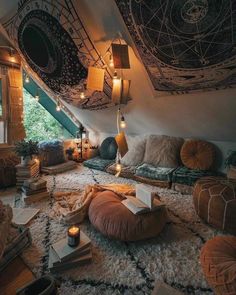 a living room filled with lots of furniture and lights hanging from the ceiling above it