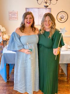 two women standing next to each other in dresses