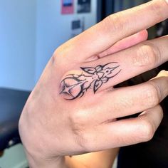 a person's hand with a small tattoo on it