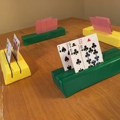 playing cards are placed on top of green bases and yellow bases, along with matching stands