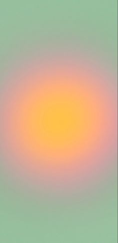 an orange and yellow circle is in the middle of a blurry background with green