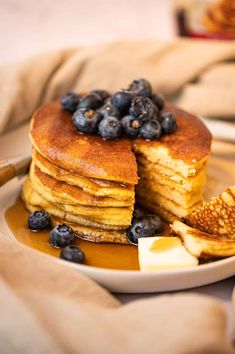 a stack of pancakes with blueberries and butter on a plate