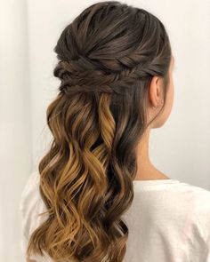 a woman with long hair in a half - up braid, wearing a white shirt