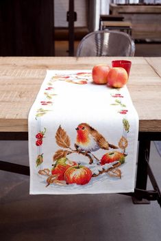 a table with apples and a bird on it