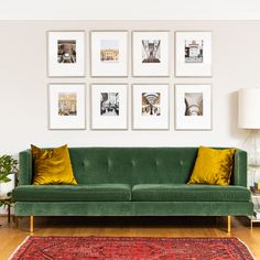 a green couch sitting in front of a wall with pictures on it