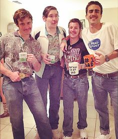 three men standing next to each other with drinks in their hands and smiling at the camera