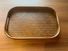 an empty metal tray sitting on top of a wooden table