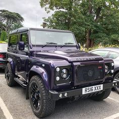 a purple land rover parked in a parking lot