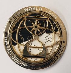 a gold and black medal with an image of the world in it's center