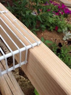 a close up of a wooden bench near flowers