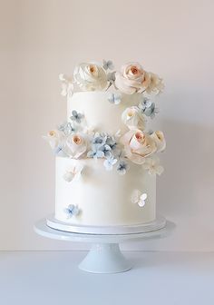 a white cake with blue and pink flowers on it