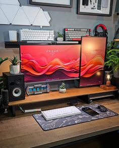 two computer monitors sitting on top of a wooden desk