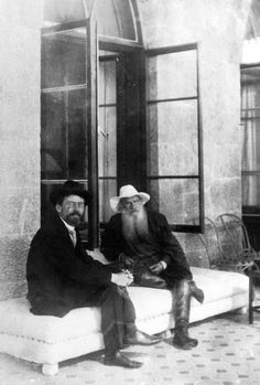 an old photo of two men sitting next to each other