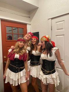 three beautiful women dressed in pirate costumes posing for a photo with one woman holding her arm around the other's shoulder